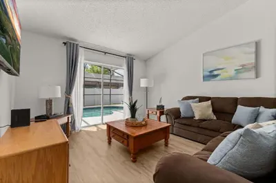 a living room with a couch and a table at Family favorite Disney pool home in Kissimmee