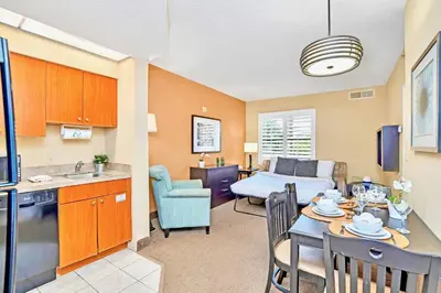 a kitchen and a living room with a table and chairs at 1BR Suite Near Universal Studios w Pool & Hot Tub in Orlando