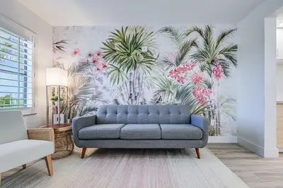 a living room with a blue couch and palm trees mural at Condo close to Epic Universe and Universal Studios in Orlando