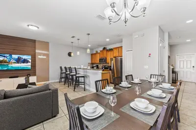 a dining room and living room with a table and chairs at 8893 Candy Palm Road in Kissimmee