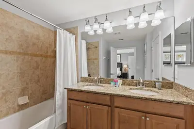 a bathroom with two sinks and a large mirror at 8893 Candy Palm Road in Kissimmee