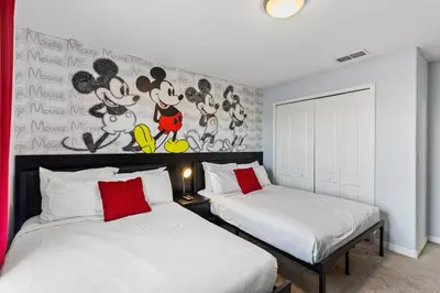 two beds in a bedroom with a mural of mickey mouse at 8893 Candy Palm Road in Kissimmee