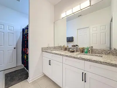 a bathroom with a sink and a large mirror at Free Water Park-Close to Disney-3 King-POOL-SPA in Orlando