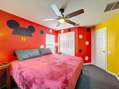 a bedroom with a bed with a mickey mouse wall at Free Water Park-Close to Disney-3 King-POOL-SPA in Orlando