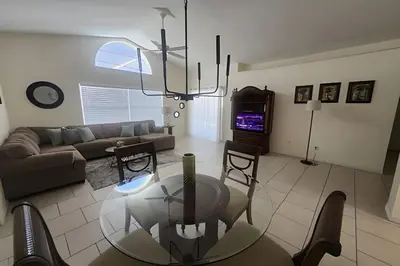a living room with a couch and a table and a television at Lake View Pool Home near Disney and Shoppings in Kissimmee
