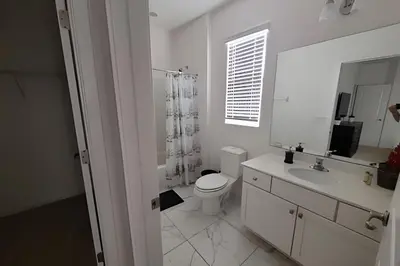 a white bathroom with a toilet and a sink at Fantastic Large Pool,Sonoma Resort in Kissimmee