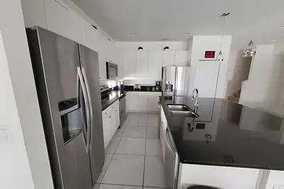 a kitchen with white cabinets and a stainless steel refrigerator at Fantastic Large Pool,Sonoma Resort in Kissimmee