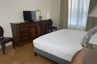 a bedroom with a bed and a dresser with a television at Emerald Island Resort : Pool & Games Room in Kissimmee