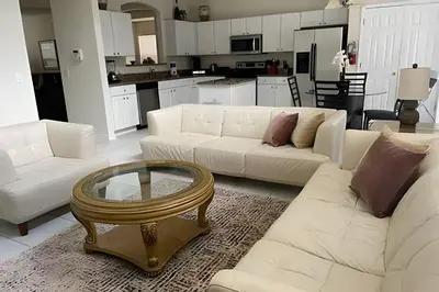 a living room with white couches and a coffee table at Emerald Island Resort : Pool & Games Room in Kissimmee