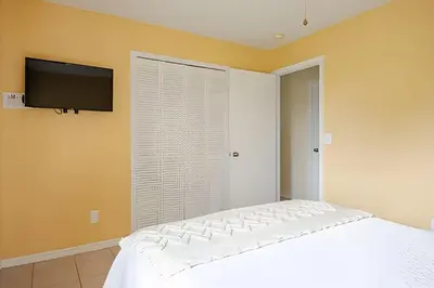 a bedroom with a bed and a tv on the wall at 10 Minutes to Disney Pool Home *Renovated* in Kissimmee
