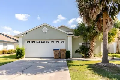 a house with a white garage and palm trees at Lakeside View Pool Home, close to Disney, Malls in Kissimmee