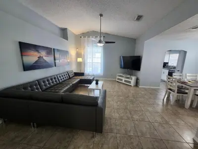 a living room with a leather couch and a table at Central Location Lakeview Pool Villa near Disney in Kissimmee