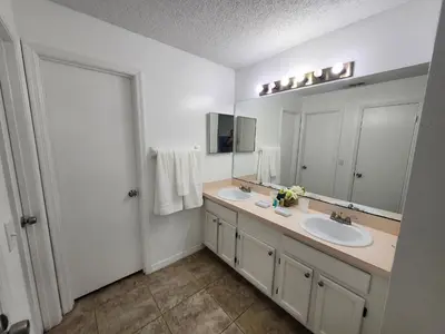 a bathroom with two sinks and a large mirror at Central Location Lakeview Pool Villa near Disney in Kissimmee
