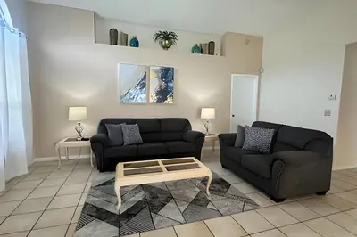 a living room with two couches and a coffee table at 10 Minutes to Disney! Pool Home Large Lot in Kissimmee