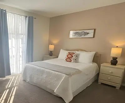 a bedroom with a bed with two night stands and two lamps at 10 Minutes to Disney! Pool Home Large Lot in Kissimmee