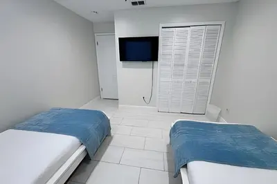 a bedroom with two beds and a flat screen tv at 10 Minutes to Disney! Pool Hom, Large Backyard in Kissimmee