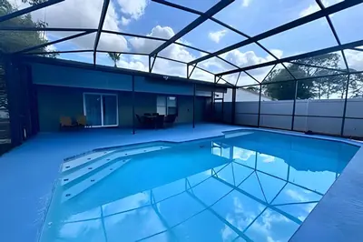 a swimming pool in a house with a glass roof at 10 Minutes to Disney! Pool Hom, Large Backyard in Kissimmee