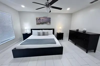 a bedroom with a bed and a ceiling fan at 10 Minutes to Disney! Pool Hom, Large Backyard in Kissimmee