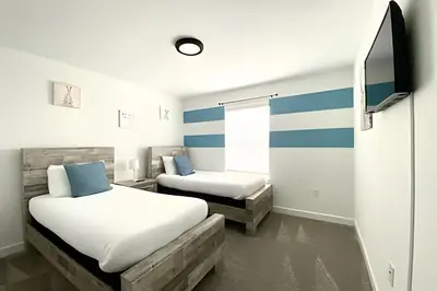 two beds in a room with blue and white stripes at Luxurious Home w/ Pool Near Disney in Kissimmee