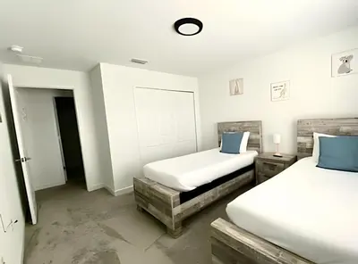 two beds in a room with white walls and blue pillows at Luxurious Home w/ Pool Near Disney in Kissimmee