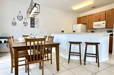 a kitchen with a dining room table and chairs at Bella Vida Resort Pool Home near Disney in Kissimmee