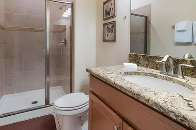 a bathroom with a sink and a toilet and a shower at Storey Lake Private Pool Home Near Disney in Kissimmee
