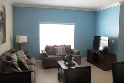 a living room with a couch and a tv at Storey Lake Private Pool Home Near Disney in Kissimmee
