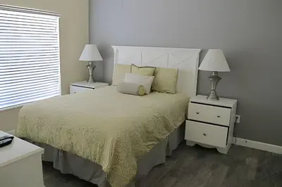 a bedroom with a bed with two night stands and two lamps at Storey Lake Private Pool Home Near Disney in Kissimmee