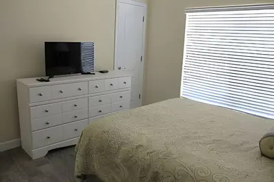 a bedroom with a bed and a television on a dresser at Storey Lake Private Pool Home Near Disney in Kissimmee