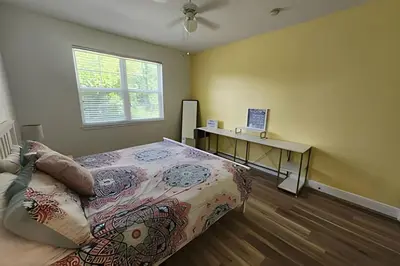 a bedroom with a bed and a desk and a window at Runaway Beach Club Condo near Disney in Kissimmee