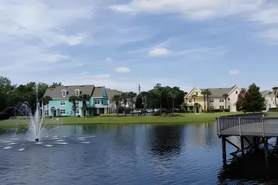 a fountain in the middle of a lake with houses at Runaway Beach Club Condo near Disney in Kissimmee