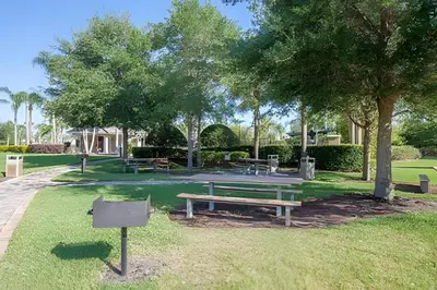 a park with three picnic tables and trees at Vista Cay Spacious Convention Center/Disney in Orlando
