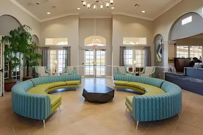 a lobby with blue and yellow couches and tables at Vista Cay Spacious Convention Center/Disney in Orlando