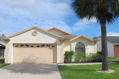 a house with a palm tree in front of it at Premium Pool Villa Centrally Located near Disney in Kissimmee