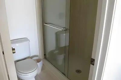 a bathroom with a toilet and a glass shower at Premium Pool Villa Centrally Located near Disney in Kissimmee