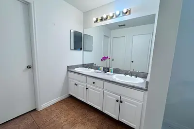 a bathroom with two sinks and a large mirror at Corner Lot Pool Home Central Located near Disney in Kissimmee