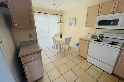 a kitchen with white appliances and a table with chairs at Huge Lot, Private Pool Home Centrally Located in Kissimmee