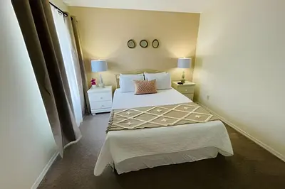 a small bedroom with a bed and two night stands at Huge Lot, Private Pool Home Centrally Located in Kissimmee