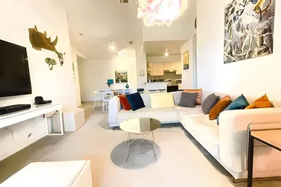 a living room with a white couch and a tv at Cozy & Bright Condo in Legacy Dunes near Disney in Kissimmee