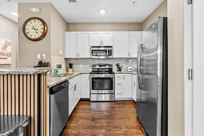a kitchen with white cabinets and a stainless steel refrigerator at NEW 4Bedrooms At LucayaClose to Disney in Kissimmee
