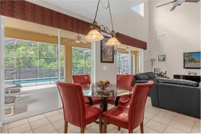 a dining room and living room with a table and chairs at 2767LKD-Emerald Island Resort home in Kissimmee