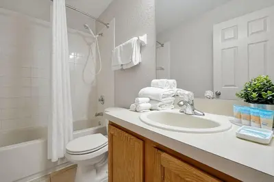 a white bathroom with a sink and a toilet at Resort Access and Great Location in Orlando