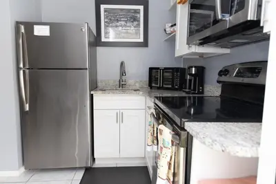 a kitchen with a stainless steel refrigerator and white cabinets at Private 1 Bed 1 Bath Orlando Oasis Shopping and Parks Nearby in Orlando