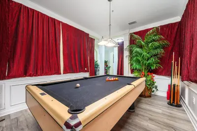 a pool table in a room with red curtains at Epic Universe Large Condo with Pool Table, Vista Cay - 2003 in Orlando