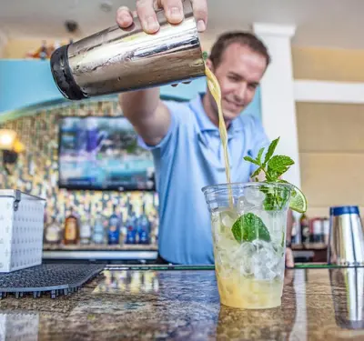 a bartender is pouring a drink into a glass at Gorgeous 3 Bed Lakeview, Vista Cay - 1010 in Orlando