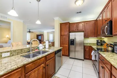 a kitchen with wooden cabinets and a stainless steel refrigerator at Gorgeous 3 Bed Lakeview, Vista Cay - 1010 in Orlando