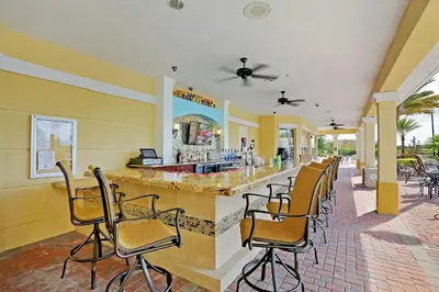 a bar in a restaurant with chairs around it at Epic Universe Lake View Condo, Vista Cay - 1005 in Orlando