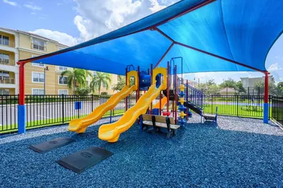 a playground with a slide and a blue canopy at Beautiful Epic Universe Condo, Vista Cay - 1004 in Orlando