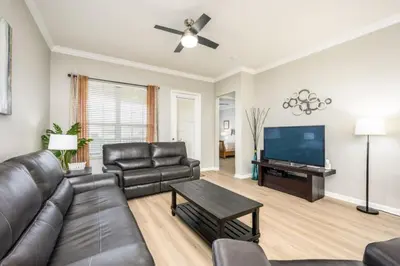 a living room with a leather couch and a flat screen tv at Epic Universe Beautiful Modern Condo - Vista Cay Resort - 2007 in Orlando
