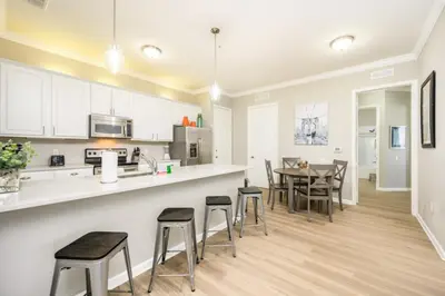a kitchen and dining room with a table and chairs at Epic Universe Beautiful Modern Condo - Vista Cay Resort - 2007 in Orlando